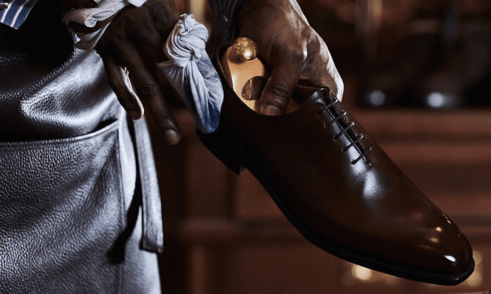 man cleaning brown shoes